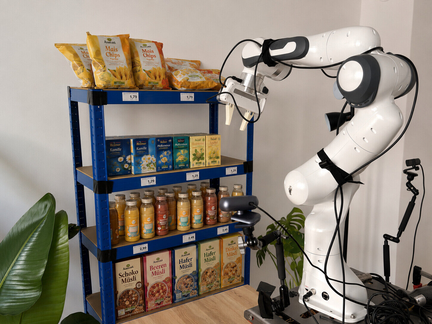 Roboterarm räumt ein voll bestücktes Regal mit Lebensmitteln ein
